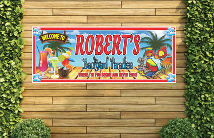 Personalized backyard paradise welcome sign featuring a tropical parrot relaxing on a chaise lounge with a cocktail in his hand, surrounded by exotic drinks. All lines of text are editable for a custom touch.