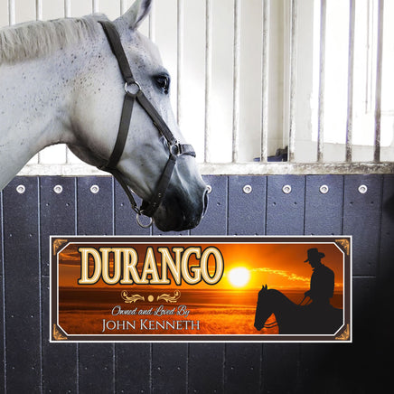  Custom horse stall sign with personalized text, featuring a sunset background and a silhouette of a horse and rider. The horse's name is displayed prominently, with "Owned and Loved By" and the owner's name beneath.