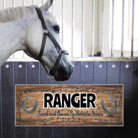  Personalized horse stall sign with a rustic brown weathered wood background, barbed wire accents, and custom text. Features the horse's name in a bold Western-style font and "Loved and Owned By" in an elegant script.