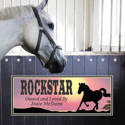 Personalized horse stall sign with a sunset background and horse silhouette. Features custom text including the horse's name and "Loved and Owned By." Rustic and elegant design perfect for barns and stables.