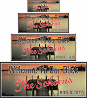 Personalized pier welcome sign featuring a photographic background of a clear lake, wooden pier, illuminated skyline, and pink-gold evening sunset, with fully editable text lines for a custom touch.